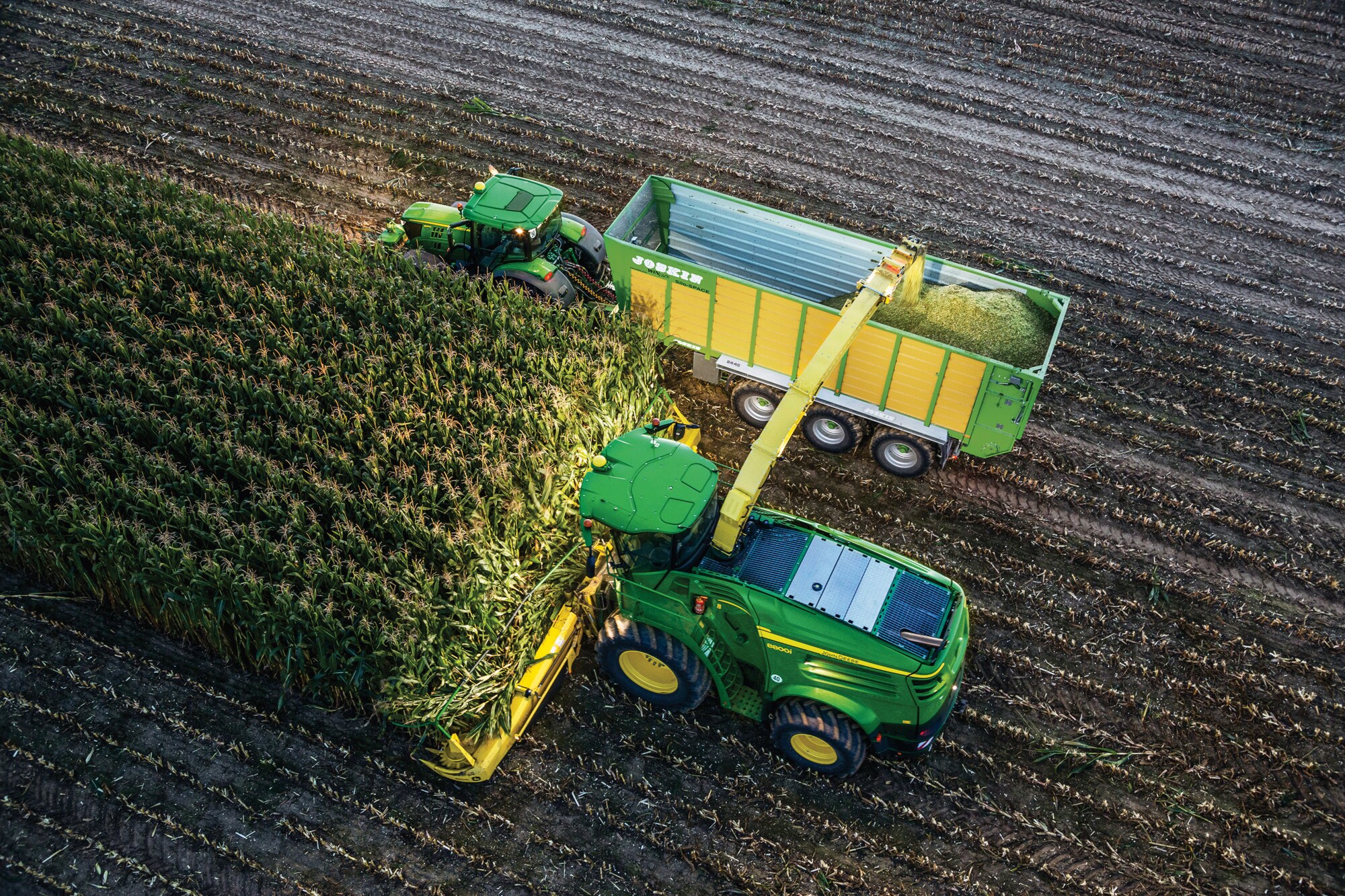 Nebeneinander fahrende Feldhäcksler und Traktor