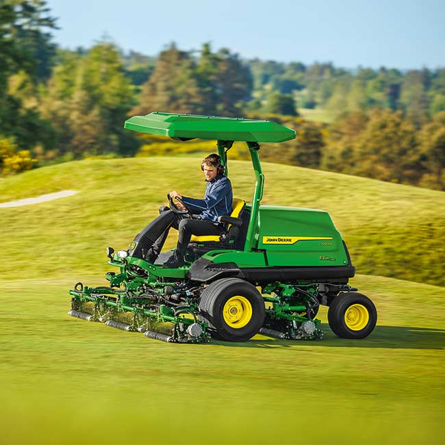 Ein Greenkeeper arbeitet auf einer Rasenfläche mit einem John Deere Fairway-Mäher