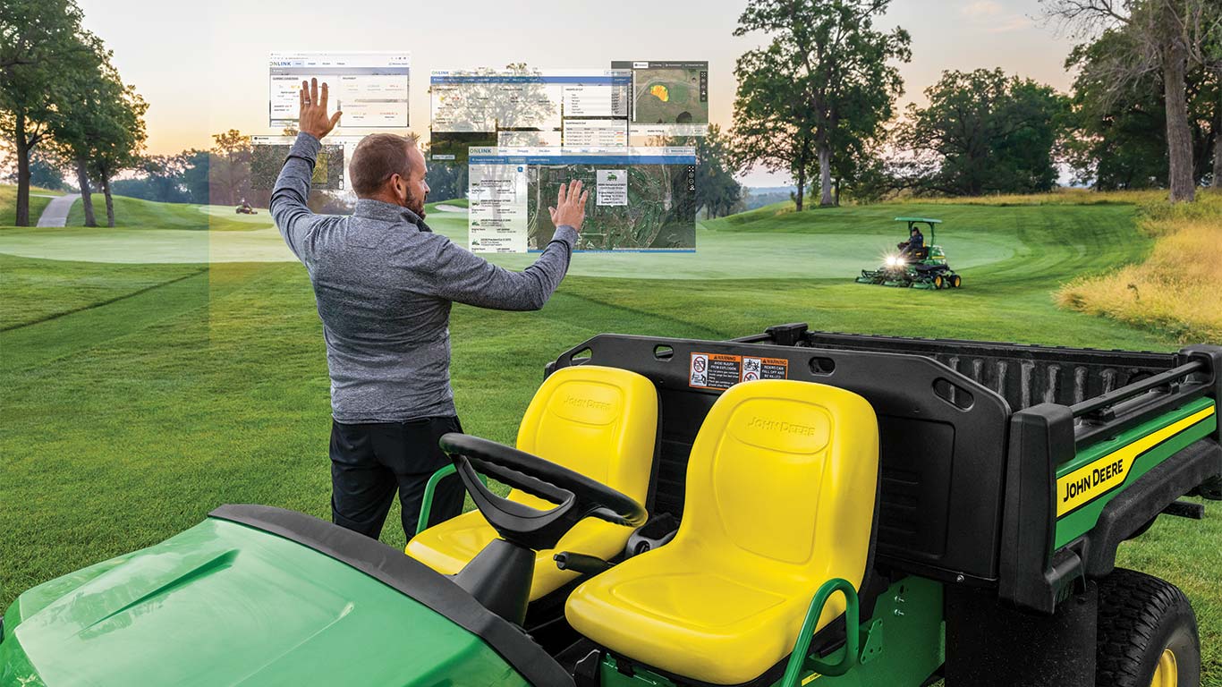 Ein Greenkeeper arbeitet mit imaginären Smart-Greenkeeping-Displays in der Luft auf einem Golfplatz.