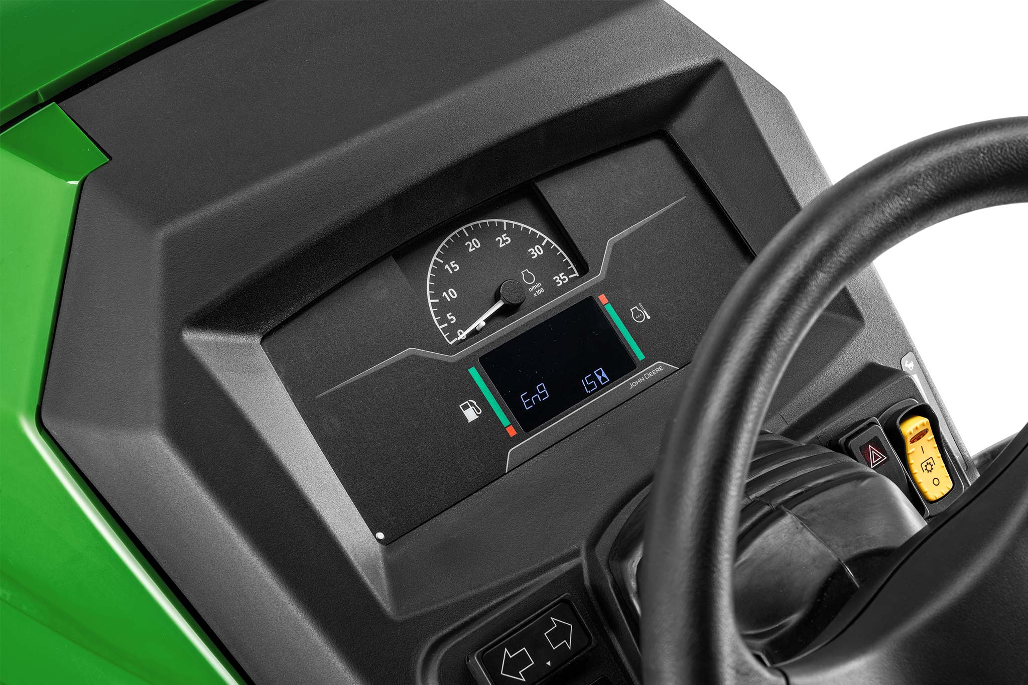 Nahaufnahme des Armaturenbretts eines John Deere Kompakttraktors mit Digitalanzeige, Manometer und Lenkrad