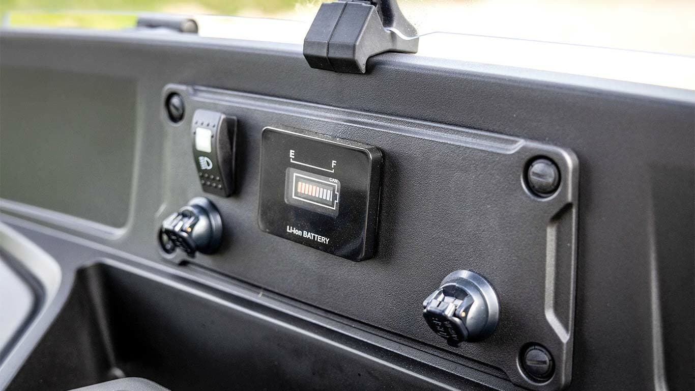 Tableau de bord d’un Gator&nbsp;GS John&nbsp;Deere électrique affichant l’indicateur de niveau de charge et les ports d’alimentation.