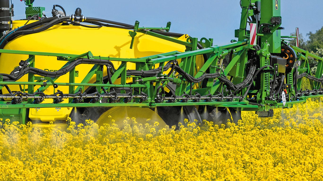 Eine Spritzmachine in dem Rapsfeld